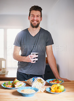 Buy stock photo Portrait of a handsome young man standing in front of meals which he has prepared in his kitchen