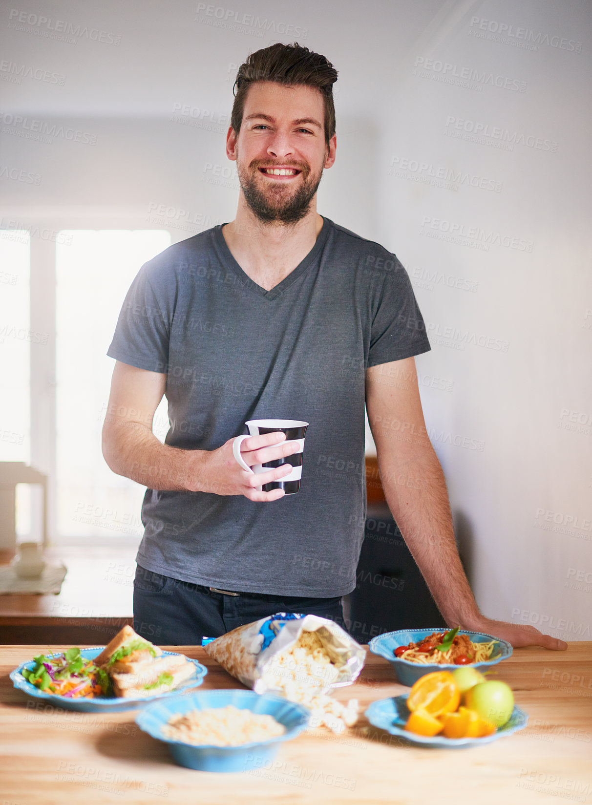 Buy stock photo Man, coffee and healthy food in kitchen for portrait with meal for nutrition breakfast, diet and wellness. Happy, male person and eating fruit, vegetable or popcorn for organic snack in the morning