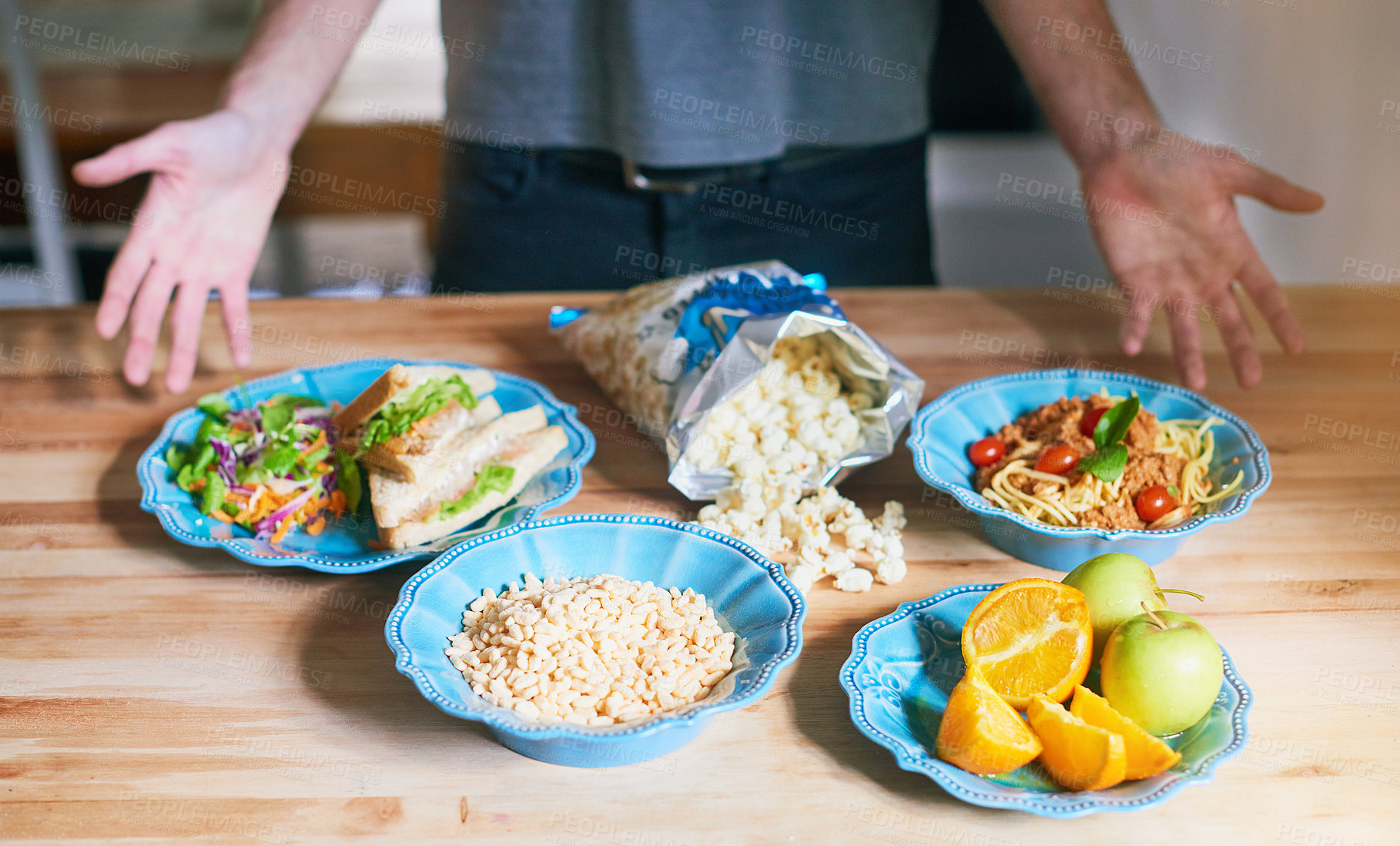 Buy stock photo Man, healthy and food on table in kitchen for options of nutrition breakfast, diet and wellness as vegan for weight loss. Male person, meal prep and fruit, vegetable or popcorn as organic snack 