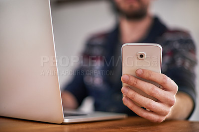 Buy stock photo Closeup shot of a man using a laptop and cellphone at home