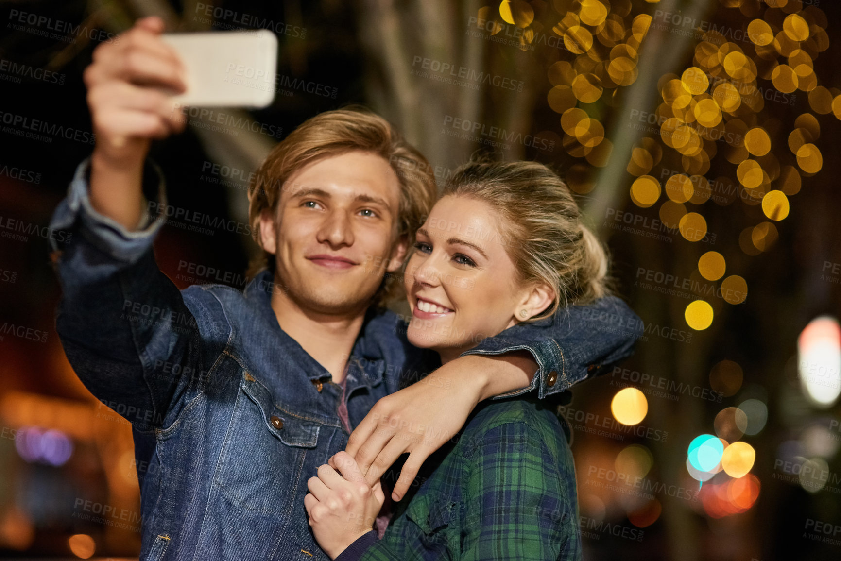 Buy stock photo Shot of a young couple taking a selfie while out on a date