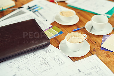 Buy stock photo Shot of cups of coffee, blueprints and color swatches on a desk