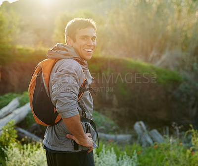 Buy stock photo Rearview portrait of a handsome male athlete standing with his hands on his hips during a hike in the forest