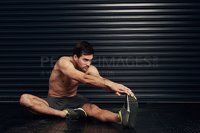 Buy stock photo Studio shot of a shirtless and well built man warming up against a dark background