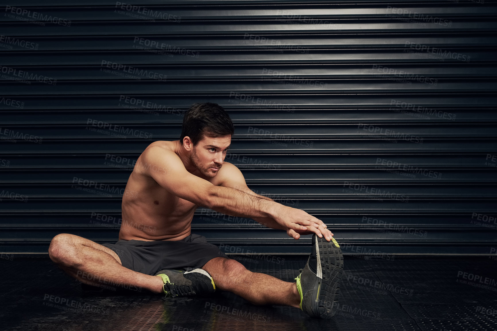 Buy stock photo Studio shot of a shirtless and well built man warming up against a dark background