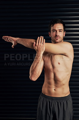 Buy stock photo Studio portrait of a shirtless and well built man warming up against a dark background