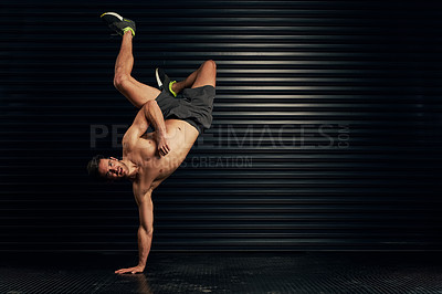 Buy stock photo Studio portrait of a shirtless and well built man breakdancing against a dark background