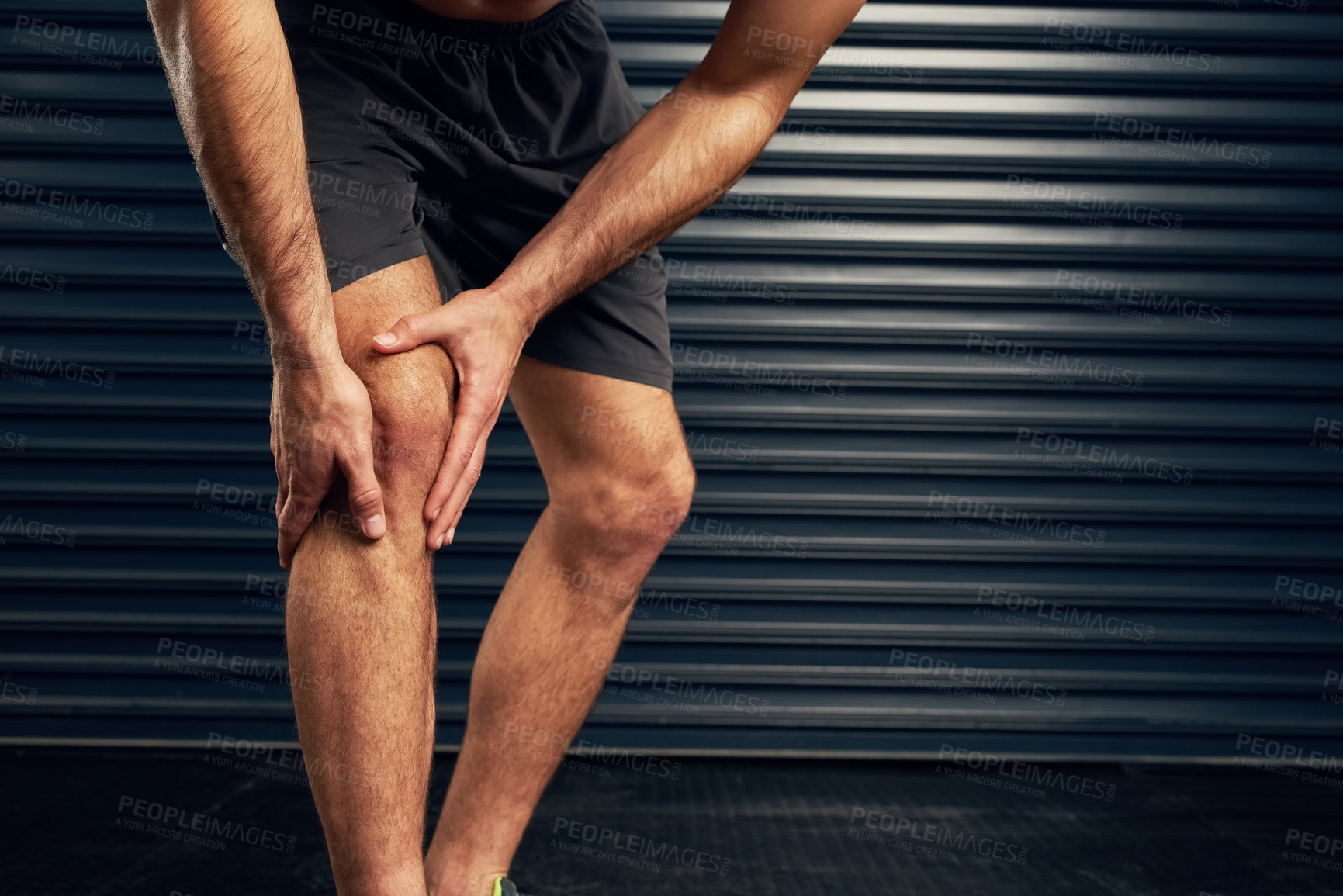 Buy stock photo Studio shot of an unrecognizable holding his knee against a dark background