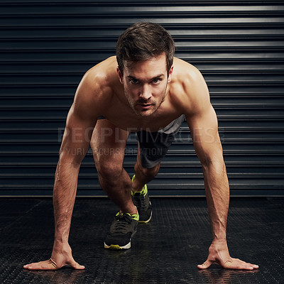 Buy stock photo Studio portrait of a shirtless and well built man getting ready for a sprint against a dark background