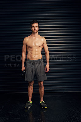 Buy stock photo Studio portrait of a shirtless and well built man standing against a dark background