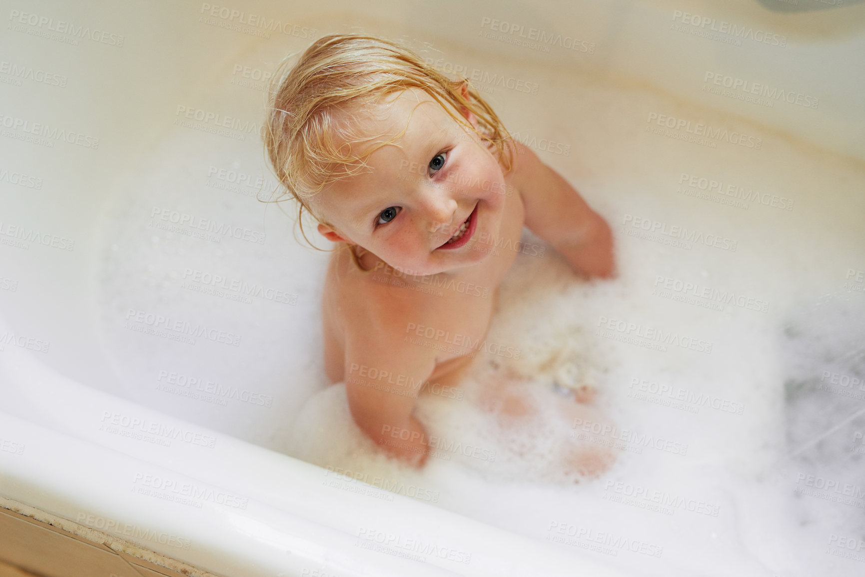 Buy stock photo Portrait, bathtub and top view of happy baby girl in water for hygiene, health or wellness in bathroom. Foam, soap and face of kid bathing, clean skin and cute infant child with bubbles in home above