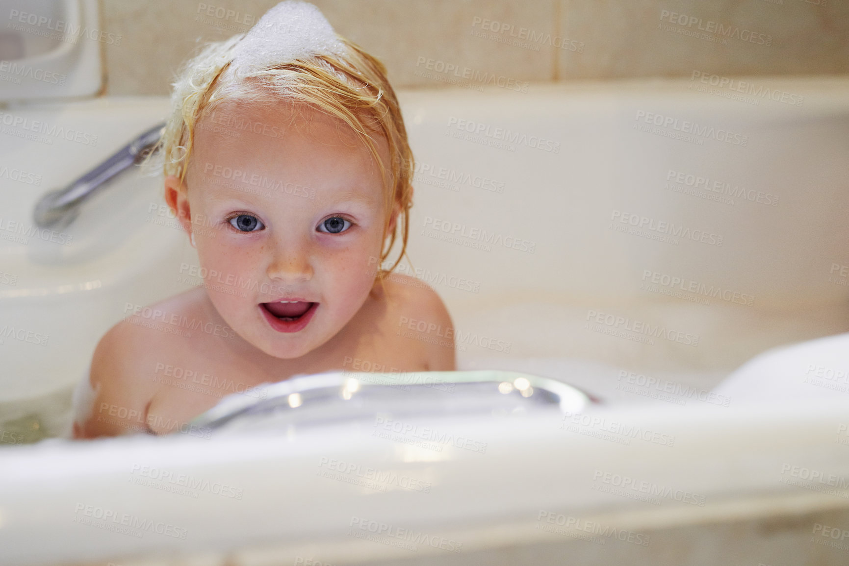Buy stock photo Portrait, bathtub and happy baby girl in water for hygiene, health or wellness in bathroom in Switzerland. Foam, soap and face of kid bathing, clean skin and cute toddler child with bubbles in home