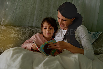 Buy stock photo Cropped shot of a mother reading her little girl a bedtime story