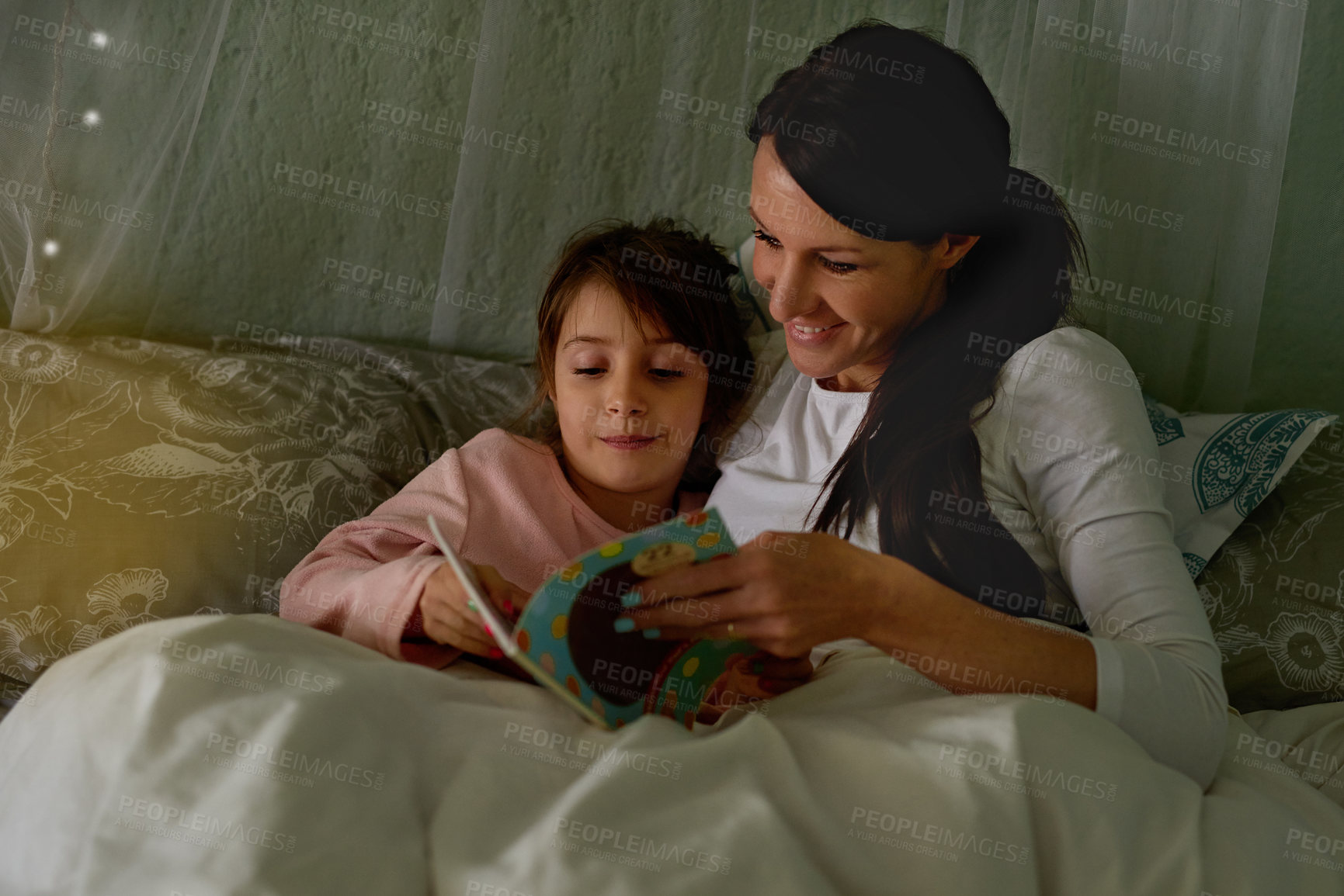 Buy stock photo Cropped shot of a mother reading her little girl a bedtime story