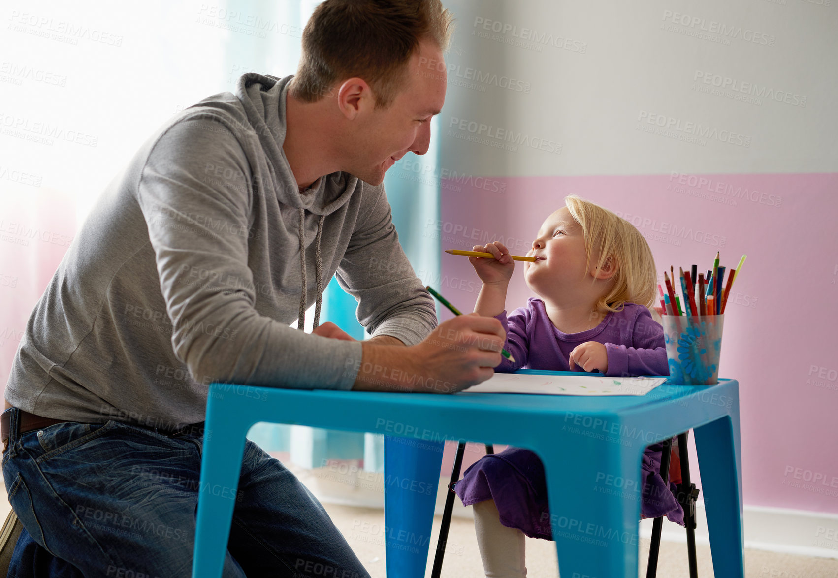 Buy stock photo Cropped shot of a father and daughter colouring in together at home