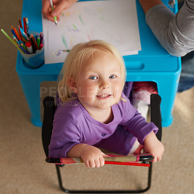 Buy stock photo Portrait of an adorable little girl colouring in at her own small table at home