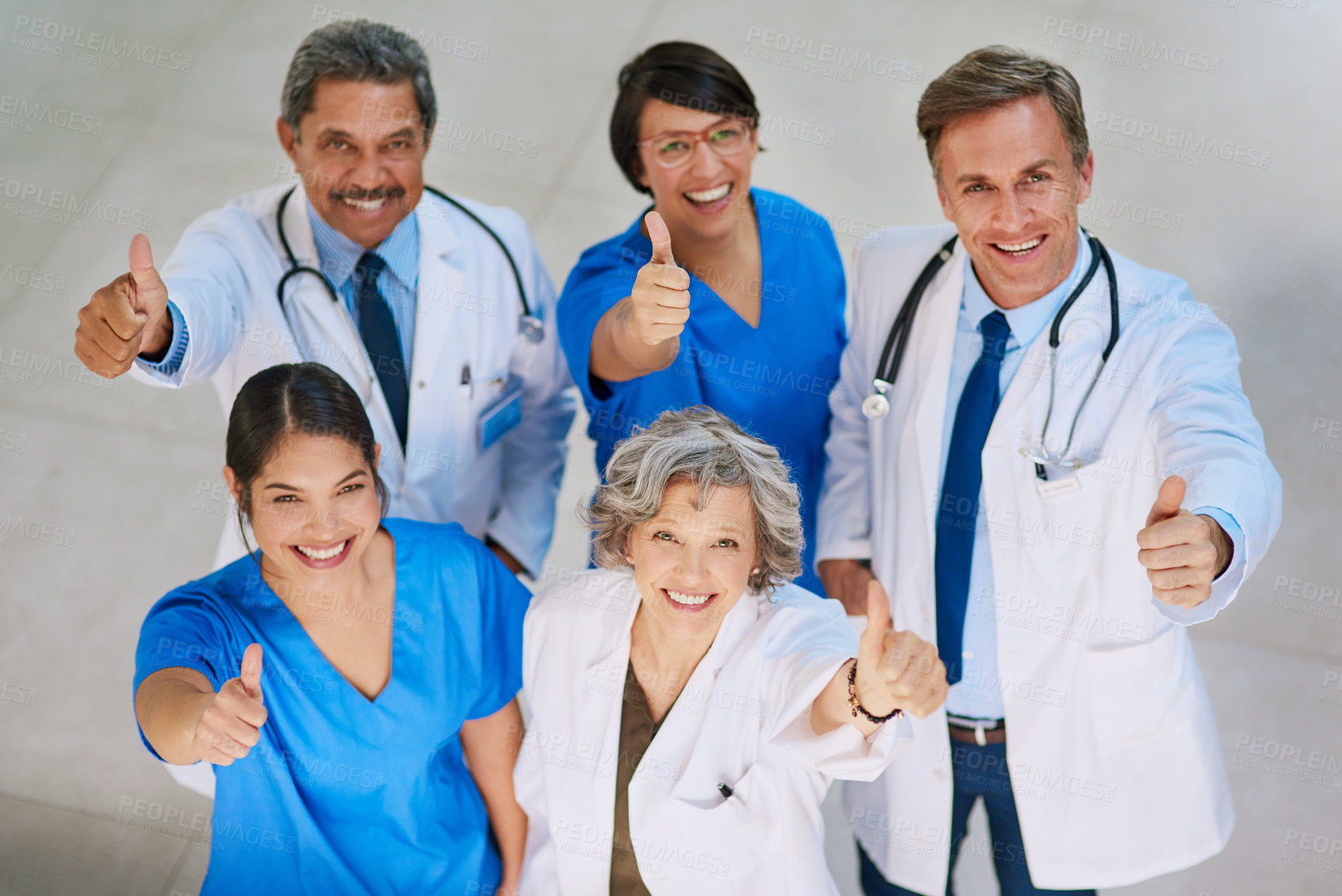 Buy stock photo High angle portrait of a medical team standing with their thumbs up in a hospital