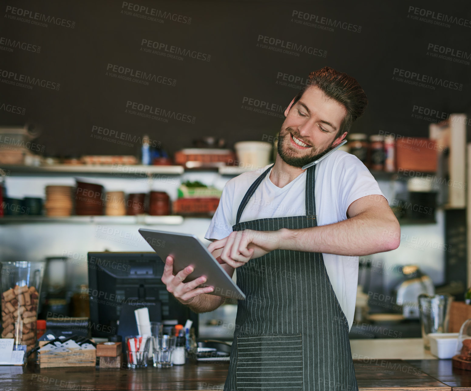 Buy stock photo Phone call, waiter and taking order on tablet in restaurant, deli or coffeeshop for work. Smile, man and talk on smartphone for customer website, service and online trade in store for sales in cafe