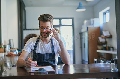 Buy stock photo Cropped shot of a young barista taking orders via cellphone
