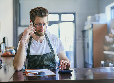 Buy stock photo Cropped shot of a young barista taking orders via cellphone