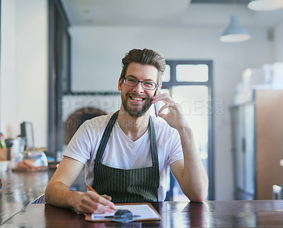 Buy stock photo Cropped portrait of a young barista taking orders via cellphone