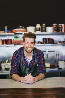 Buy stock photo Portrait of a young barista working behind the counter in his coffee shop