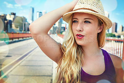 Buy stock photo Shot of a smiling young woman walking around the city in the summertime