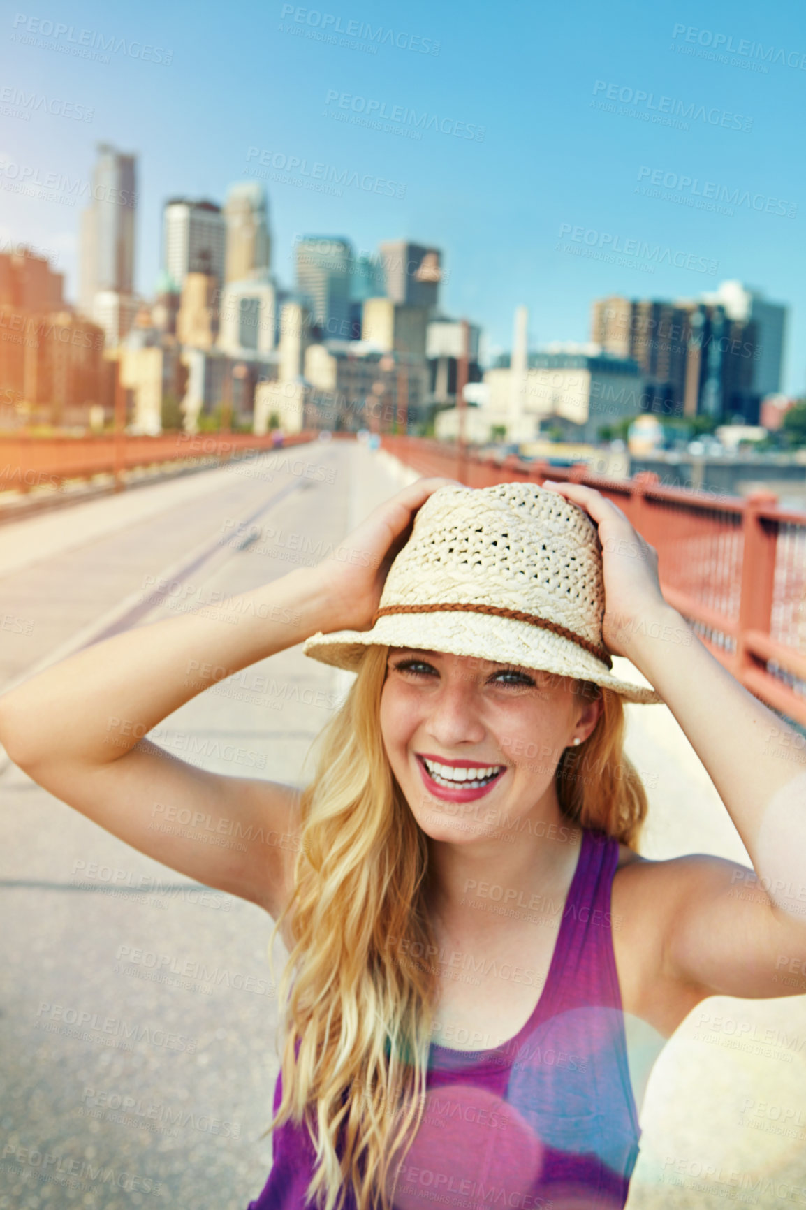 Buy stock photo Shot of a smiling young woman walking around the city in the summertime