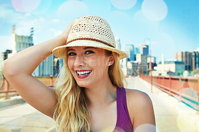 Buy stock photo Shot of a smiling young woman walking around the city in the summertime