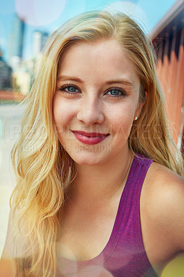 Buy stock photo Shot of a smiling young woman walking around the city in the summertime