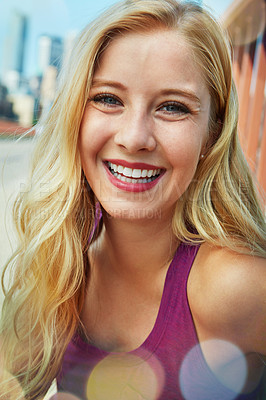 Buy stock photo Shot of a smiling young woman walking around the city in the summertime