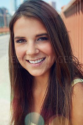 Buy stock photo Shot of a smiling young woman walking around the city in the summertime