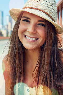 Buy stock photo Shot of a smiling young woman walking around the city in the summertime