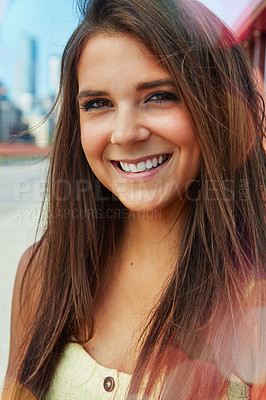 Buy stock photo Shot of a smiling young woman walking around the city in the summertime