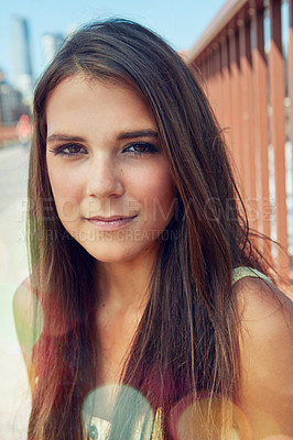 Buy stock photo Shot of a smiling young woman walking around the city in the summertime