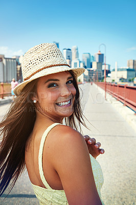 Buy stock photo Shot of a smiling young woman walking around the city in the summertime