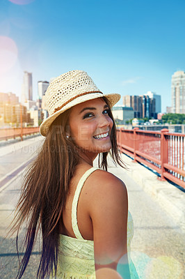 Buy stock photo Shot of a smiling young woman walking around the city in the summertime