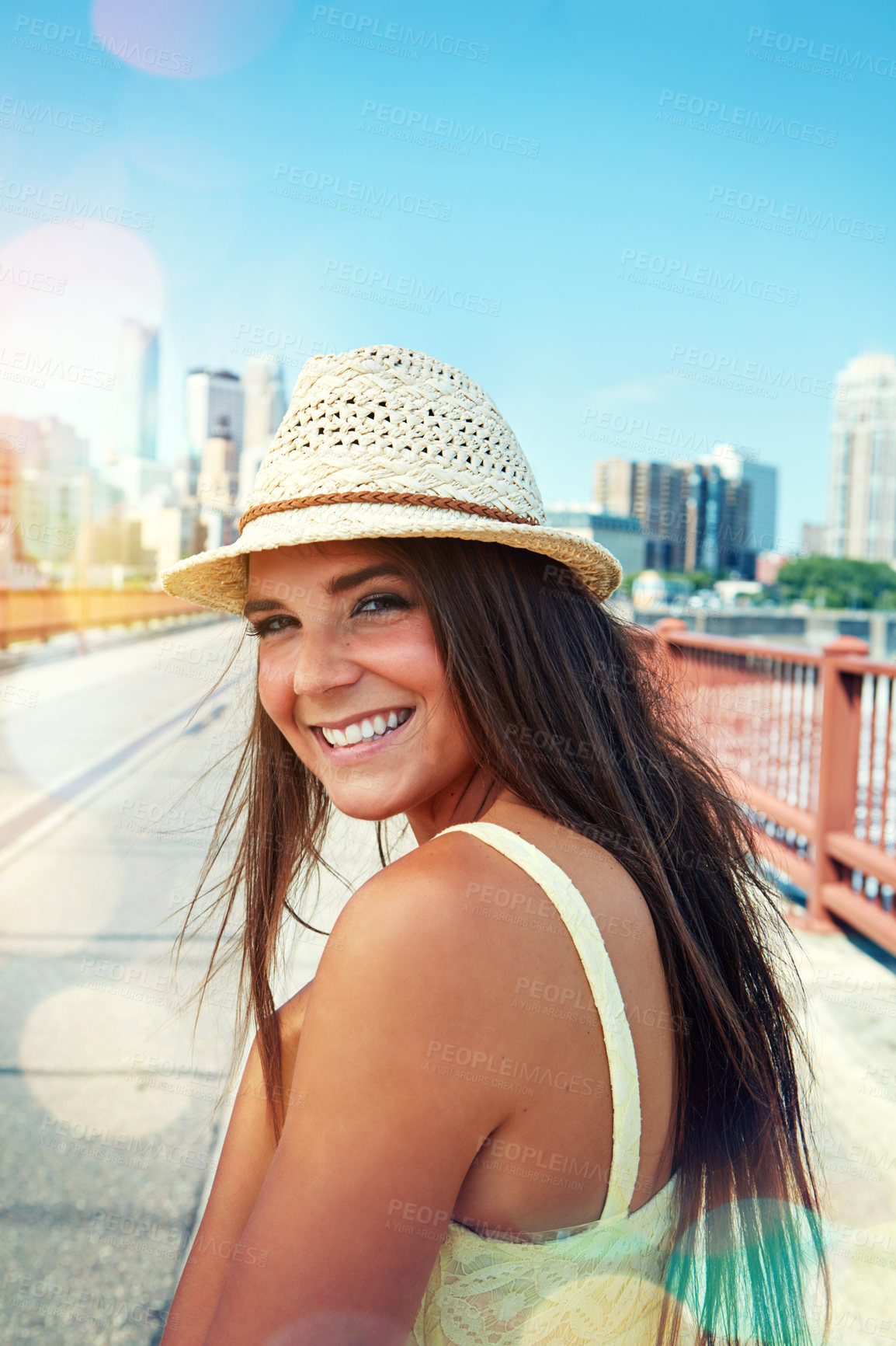 Buy stock photo Shot of a smiling young woman walking around the city in the summertime