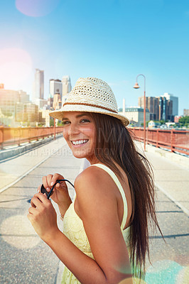 Buy stock photo Shot of a smiling young woman walking around the city in the summertime