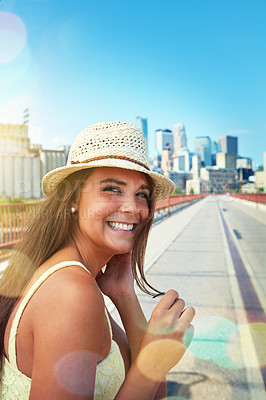 Buy stock photo Shot of a smiling young woman walking around the city in the summertime