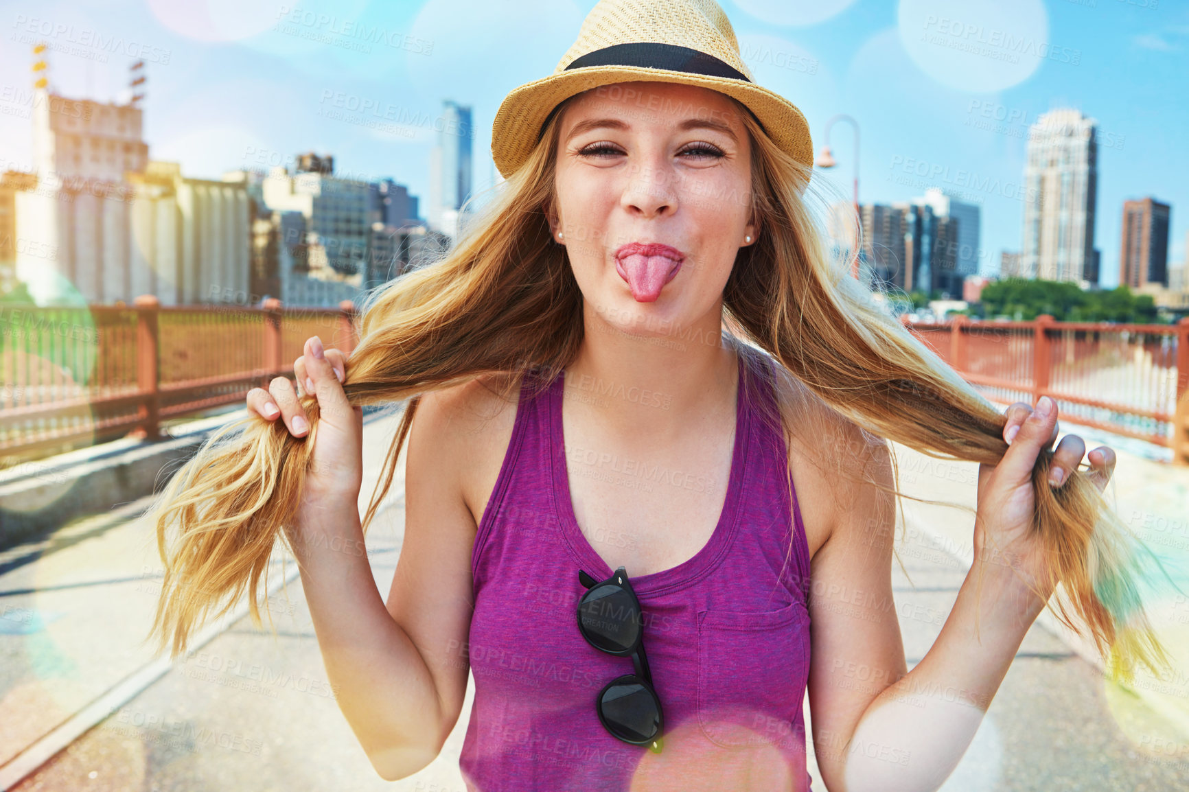 Buy stock photo Shot of a smiling young woman walking around the city in the summertime