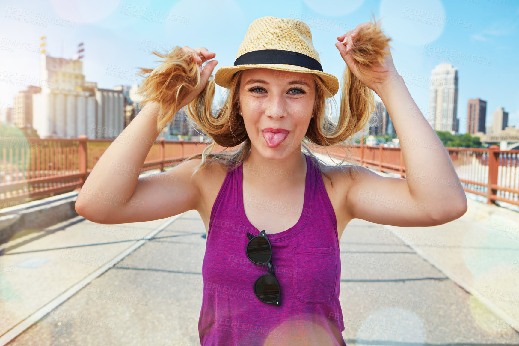 Buy stock photo Shot of a smiling young woman walking around the city in the summertime