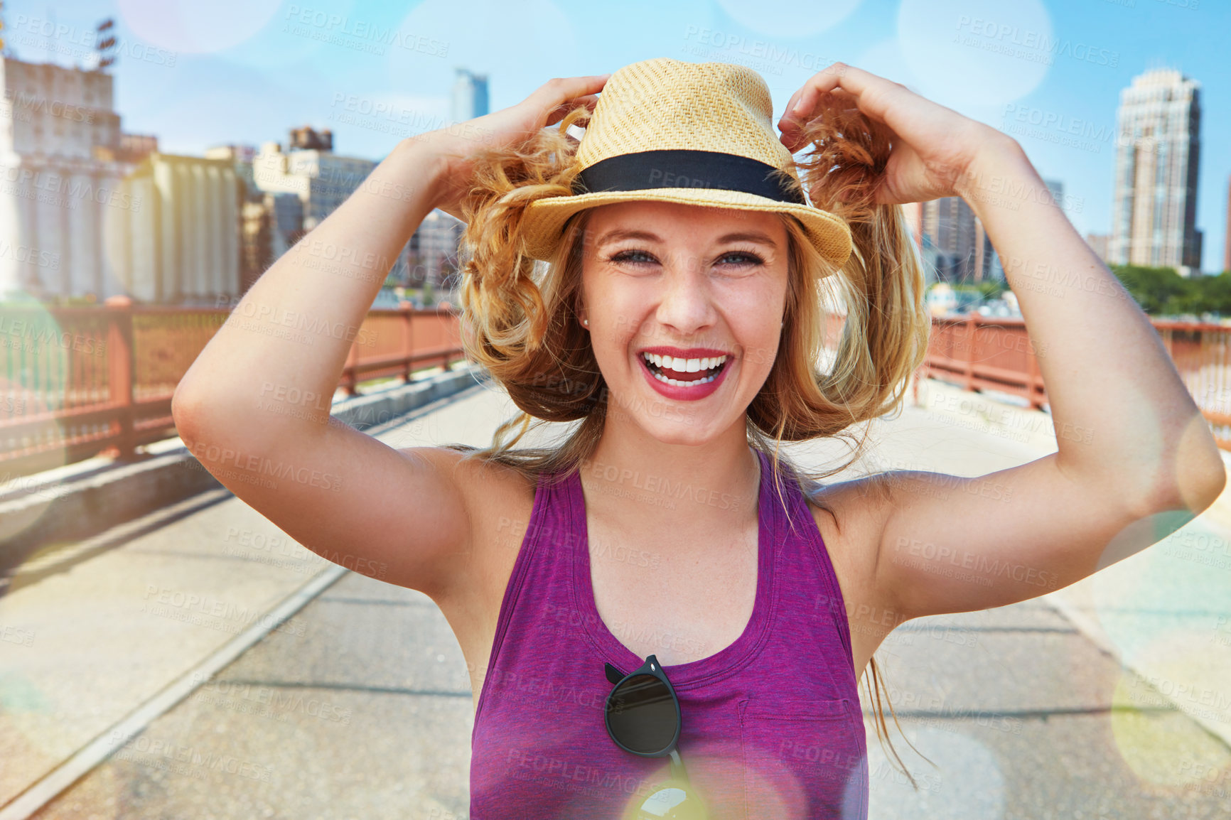 Buy stock photo Shot of a smiling young woman walking around the city in the summertime