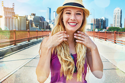 Buy stock photo Shot of a smiling young woman walking around the city in the summertime