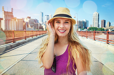 Buy stock photo Shot of a smiling young woman walking around the city in the summertime