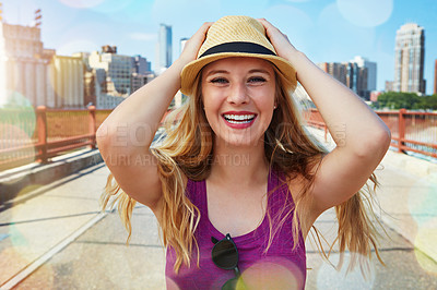 Buy stock photo Shot of a smiling young woman walking around the city in the summertime