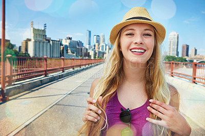 Buy stock photo Shot of a smiling young woman walking around the city in the summertime