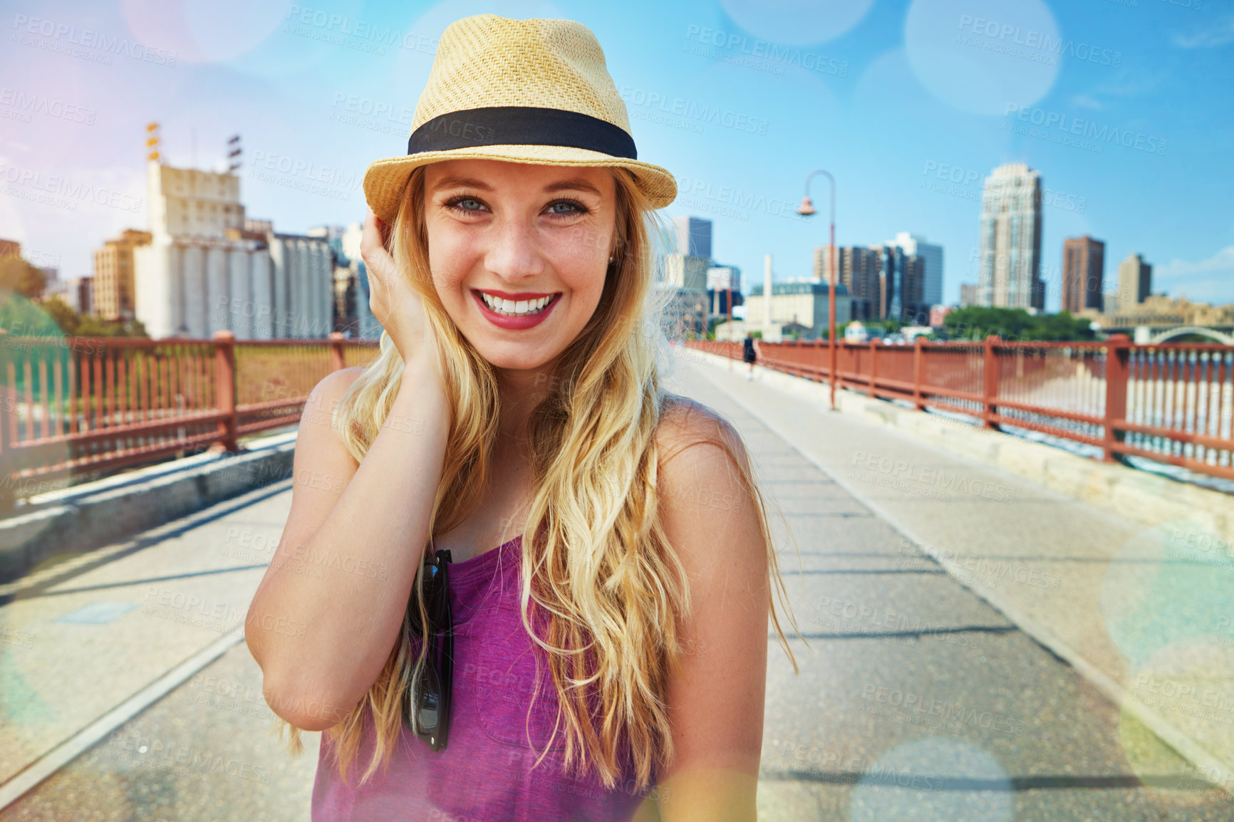 Buy stock photo Shot of a smiling young woman walking around the city in the summertime