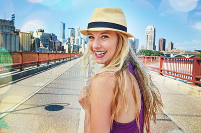 Buy stock photo Shot of a smiling young woman walking around the city in the summertime