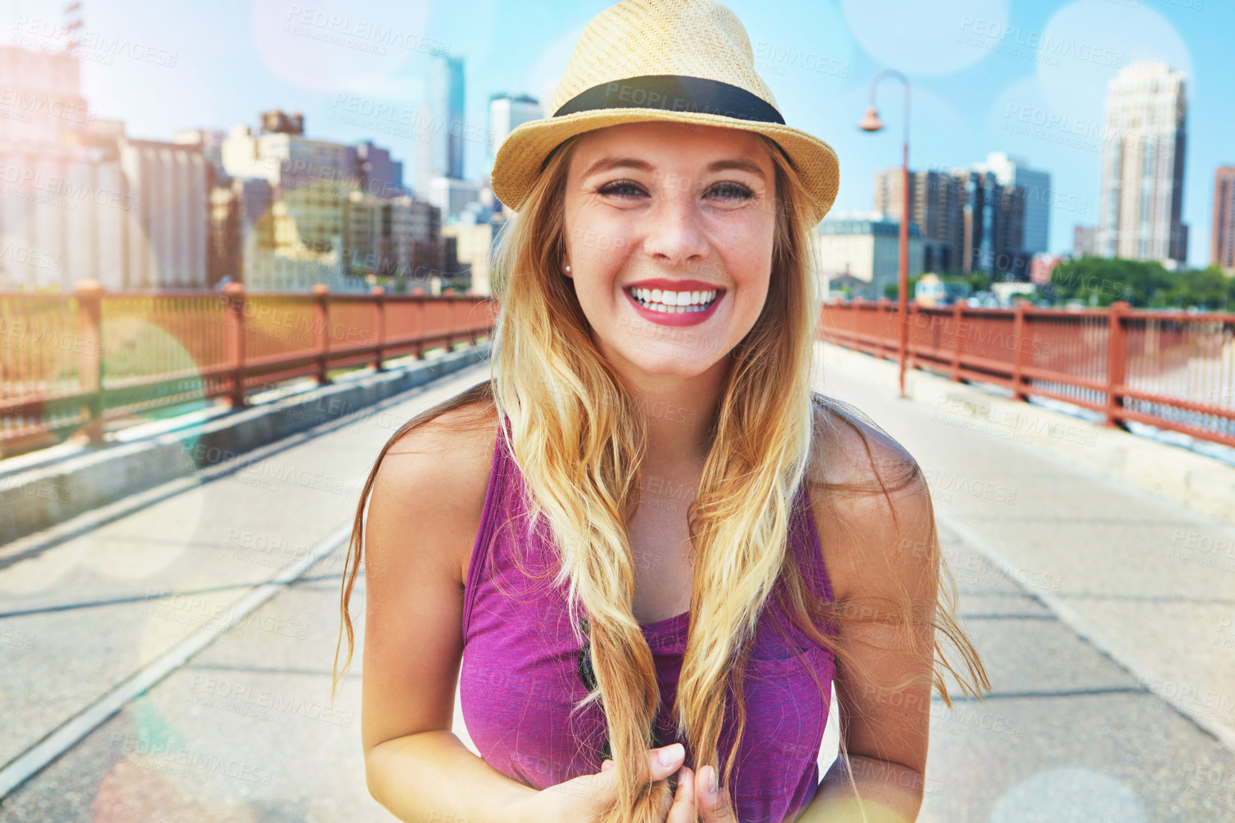 Buy stock photo Shot of a smiling young woman walking around the city in the summertime